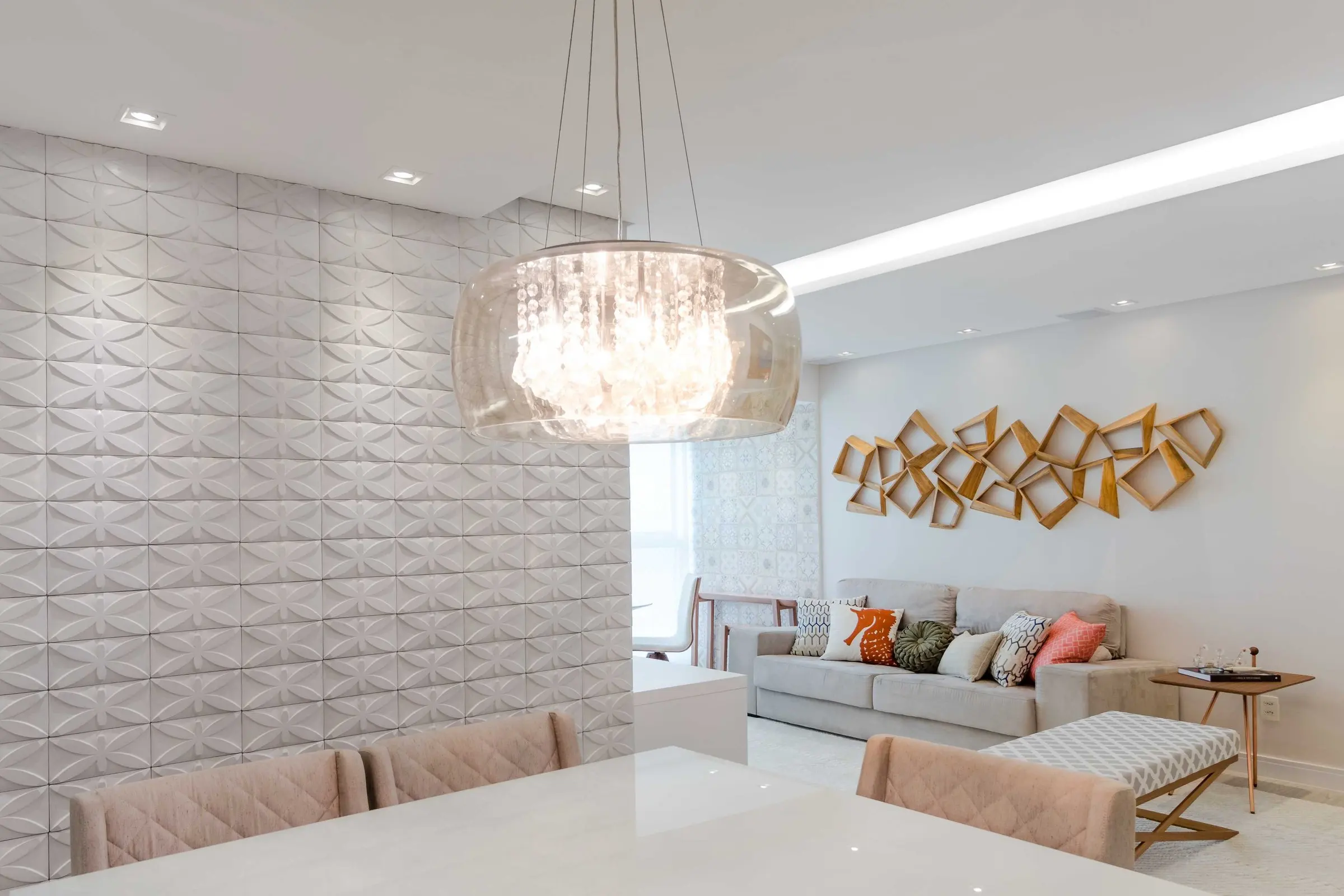 Sala de jantar com lustre de cristal e parede em relevo