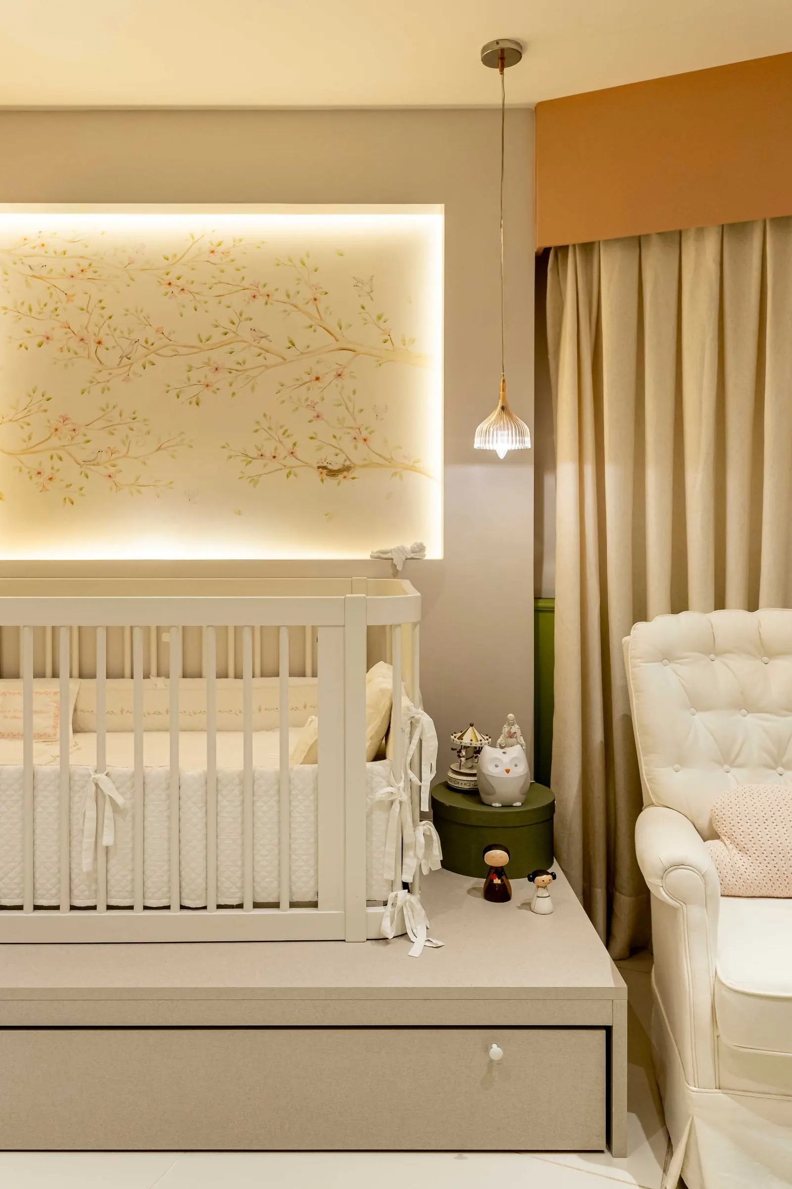 Berço sob painel iluminado com papel de parede de pássaros