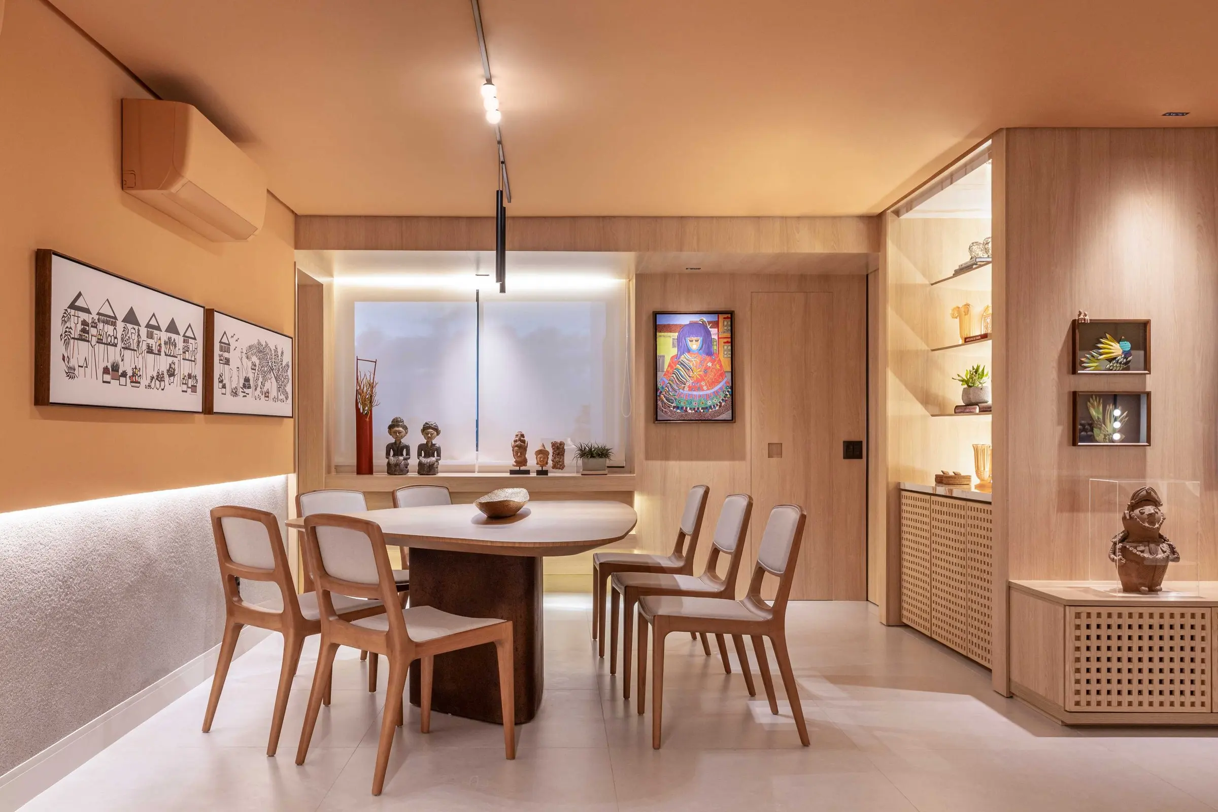 Sala de jantar com cadeiras de madeira e quadros na parede