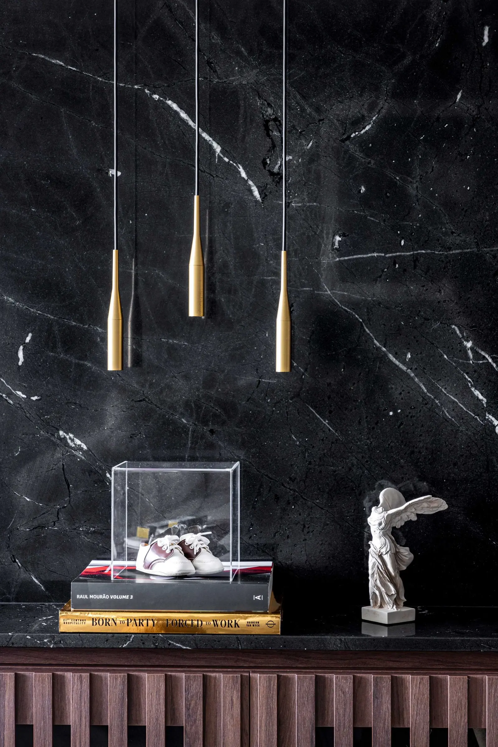 Detalhe do nicho em mármore preto com pendentes dourados